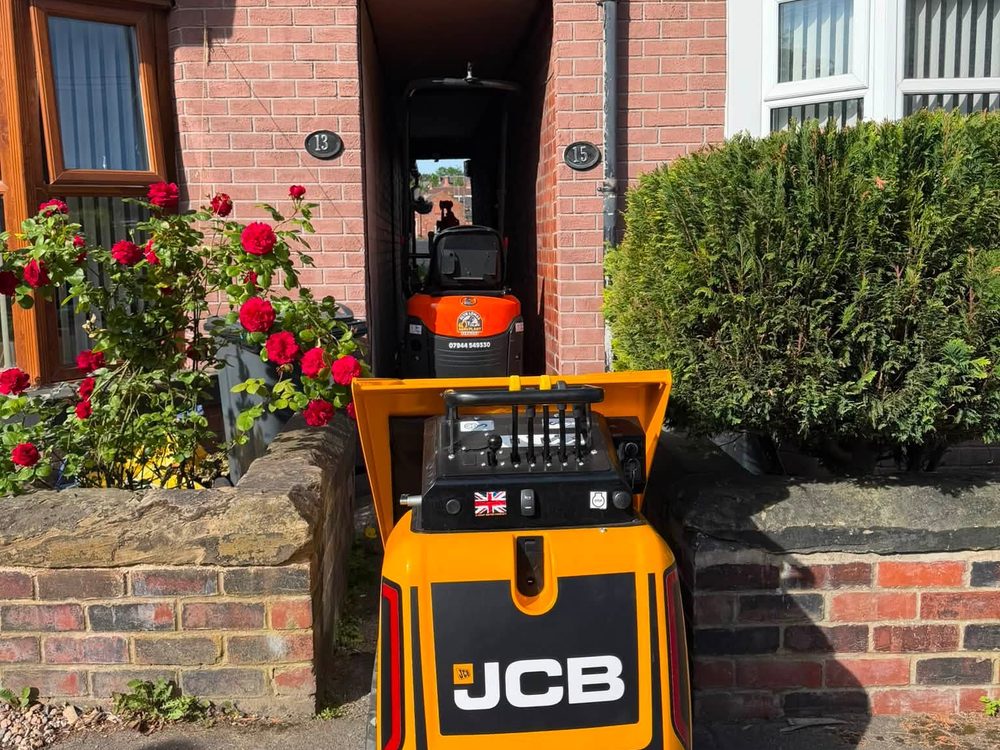JCB HTD-5 tracked high-tip dumper working through the front door of a terraced house